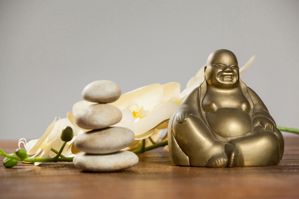 riendo-figurilla-de-buda-con-los-guijarros-de-piedra-y-la-flor (Mediana)